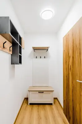 a room with a table and a wooden door at Penzion Hosnar, apartma Mucho in Bovec