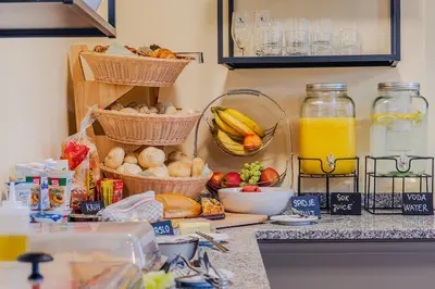 a kitchen counter with baskets of fruits and vegetables and orange juice at Penzion Hosnar, apartma Mucho in Bovec