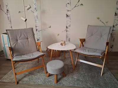 two chairs and a table in a room with trees at Prenočišče Breza in Radovljica