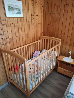 a room with a crib in a log cabin at Prenočišče Breza in Radovljica