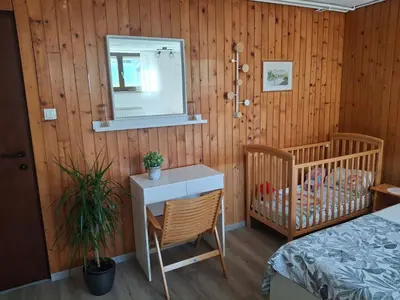 a bedroom with a bed and a table and a mirror at Prenočišče Breza in Radovljica