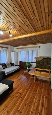 a large room with two beds and a wooden ceiling at Počitniška hiša Alica in Črna na Koroškem
