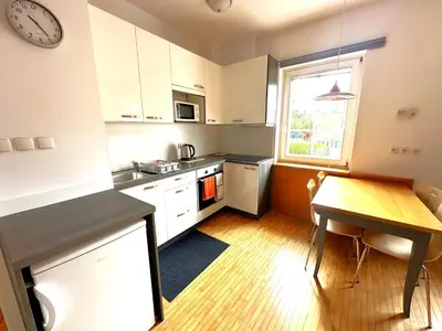 a kitchen with a table and a clock on the wall at Apartma Angela Bled in Bled