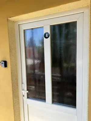 a white door with a window on a wall at Soba Pri Kosu in Slovenska Bistrica