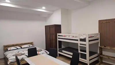 a room with a bunk bed and a table and a desk at Apartmaji Despotoski Mojstrana in Mojstrana