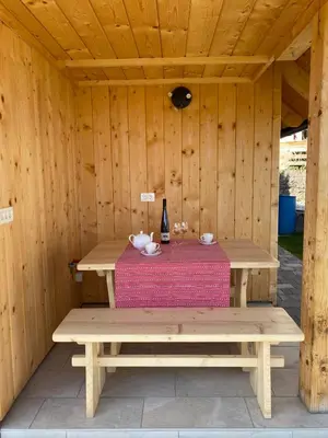 a wooden sauna with a table and a bottle of wine at Princess Mojca Holiday House in Bled