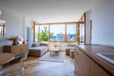 a kitchen with a living room with a large window at TJs Temple with Castle View in Ljubljana
