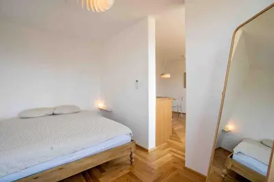 a small bedroom with a bed and a mirror at TJs Temple with Castle View in Ljubljana
