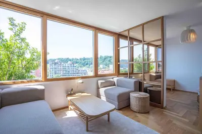 a living room filled with furniture and large windows at TJs Temple with Castle View in Ljubljana