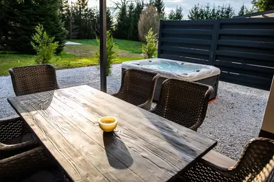 a wooden table and chairs with a hot tub at Apartments Villa Prod in Ljubljana