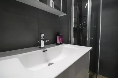 a bathroom with a white sink and a shower at Secret Corner in Ljubljana
