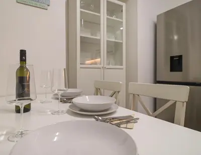 a white table with a bottle of wine and glasses at Secret Corner in Ljubljana