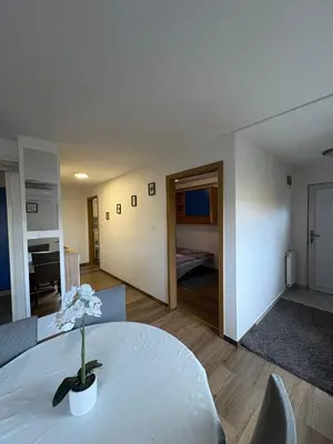 a living room with a table and a bedroom at Apartma Vinko in Ljubljana