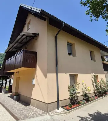 a building with a balcony on the side of it at Hiša JAVORNIK BOHINJ in Bohinj