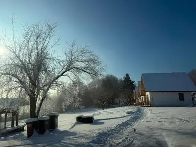 a snow covered street with trash cans and a house at Oaza miru in zdravja Goričko in Moravske Toplice