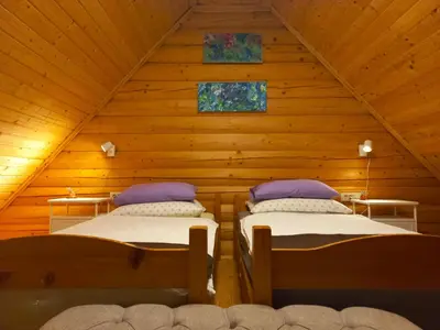 a room with two beds in a wooden cabin at Oaza miru in zdravja Goričko in Moravske Toplice