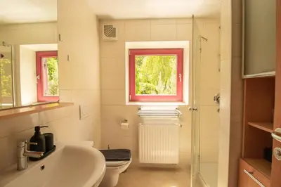 a bathroom with a sink and a toilet and a window at Bohinj Cozy Escape Holiday Home in Bohinj