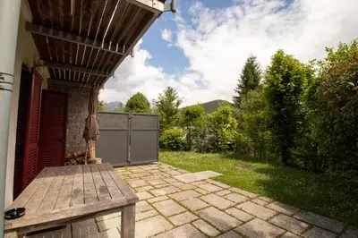 a patio with a bench in a yard at Bohinj Cozy Escape Holiday Home in Bohinj