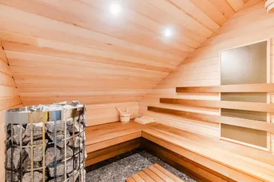 a sauna with wooden walls and wooden flooring at Alps2sea Apartment House in Srpenica