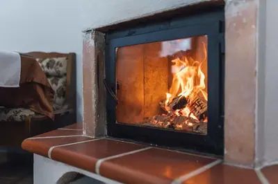 a brick fireplace with a fire in it at Harmony Resort in Cerklje na Gorenjskem
