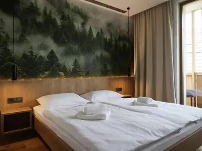 a bedroom with two beds with white towels on them at Bohinj River House Spa&Sport in Bohinj