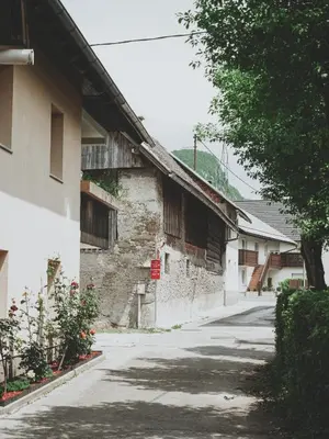 an empty street next to a white building at Bohinj River House Spa&Sport in Bohinj