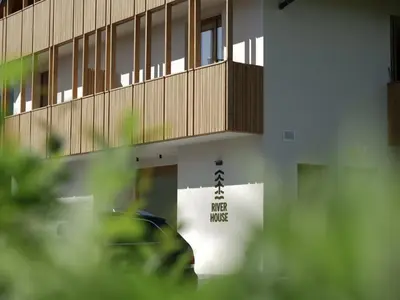 a building with a sign on the side of it at Bohinj River House Spa&Sport in Bohinj