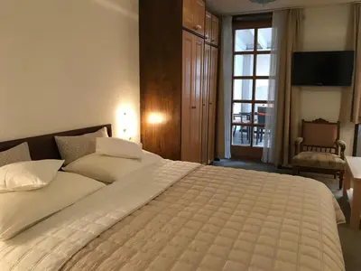 a bedroom with a large white bed and a window at Apartmaji Sušnik in Bled
