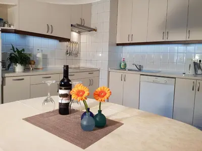 a kitchen with a table with a bottle of wine and flowers at Apartmaji Sušnik in Bled