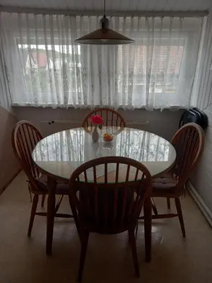 a dining room table with two chairs and a table with a vase at Apartment Zorec in Maribor