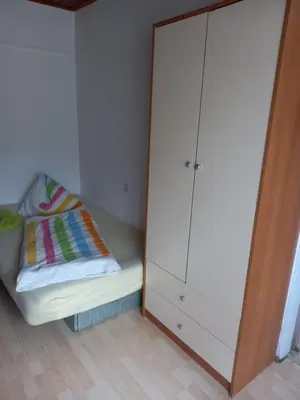 a bedroom with a white cabinet and a bed at Apartment Zorec in Maribor