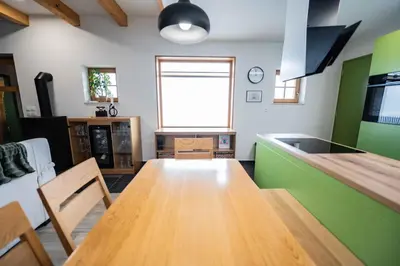 a kitchen with a wooden table and green walls at Holiday home in Trebnje - Kranjska (Krain) 53751 in Trebnje