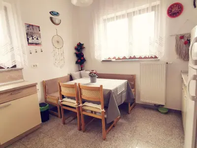 a dining room with a table and chairs in a kitchen at Apartma Pristavica in Veliki Gaber