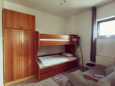 a small bedroom with a bunk bed and a cabinet at Apartma Pristavica in Veliki Gaber