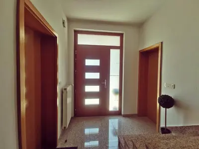an empty hallway with a door and a potted plant at Apartma Pristavica in Veliki Gaber