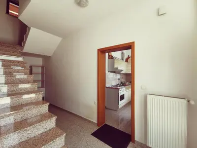 a hallway with a staircase and a kitchen in a house at Apartma Pristavica in Veliki Gaber