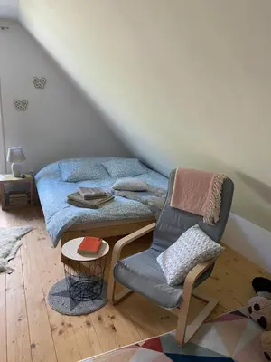 a bed and a chair in a room at Apartma Confine in Rateče