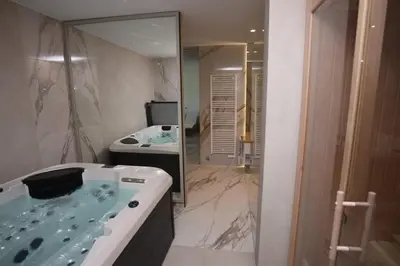 a bathroom with a tub and a sink and a mirror at Smart & Wellness Villa in Ptuj