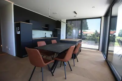 a dining room with a black table and orange chairs at Smart & Wellness Villa in Ptuj