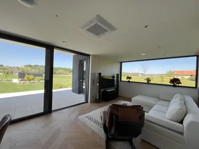 a living room with a white couch and a television at Smart & Wellness Villa in Ptuj