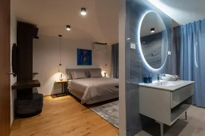 a bedroom with a bed and a sink and a mirror at Villa EVA Resort & Boutique in Dobrovo