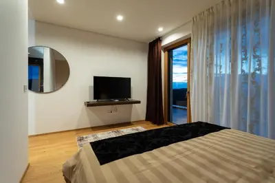 a bedroom with a bed and a tv and a window at Villa EVA Resort & Boutique in Dobrovo
