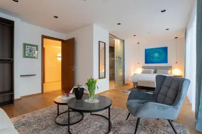 a living room with a bed and a chair and a table at Villa EVA Resort & Boutique in Dobrovo
