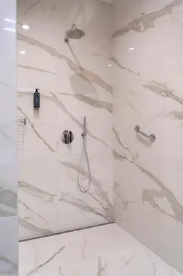 a bathroom with a shower with white marble walls at Villa EVA Resort & Boutique in Dobrovo