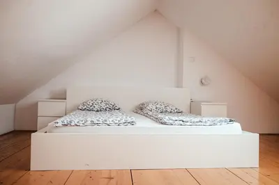 a white bed with two pillows on it in a attic at Layer Residences in Kranj