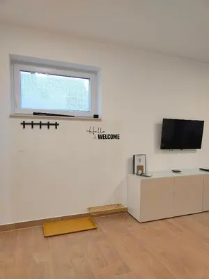 a white room with a tv and a window at Apartma WALK in in Brežice