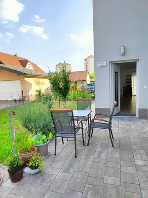 a patio with two chairs and a table and some plants at Apartma WALK in in Brežice