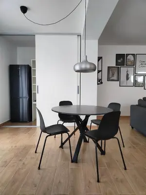 a dining table and chairs in a living room at Apartma WALK in in Brežice