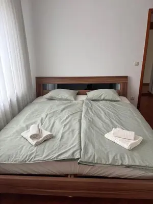 a bed with two towels sitting on top of it at Trnovo Lunca Apartment in Ljubljana