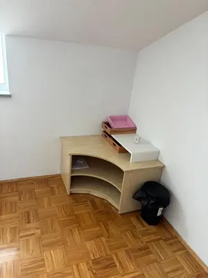 a small desk in a room with a wooden floor at Trnovo Lunca Apartment in Ljubljana